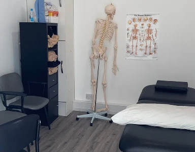 treatment and consultation room with full size skeleton and body maps on wall