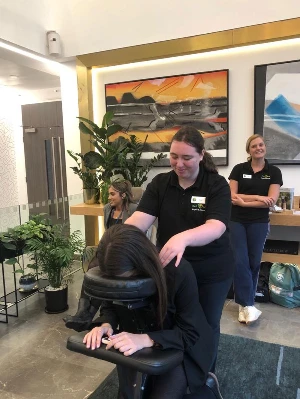 emily cox giving patient a massage in massage chair