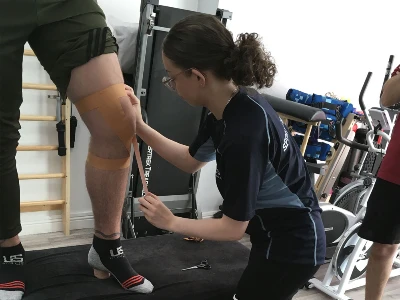 patient being treated and having physiotherapy strapping applied